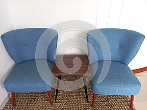 Two blue armless sofa and small wooden table at living room