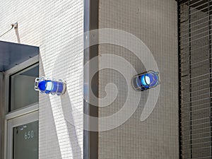 Two blue caution safety lights on corner of building outside