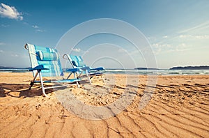 Two blue chaise-longues are on the sand ocean beach photo