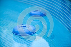 Two Blue Chlorine Dispensers sitting in pool