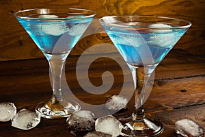 Two blue cocktails in glasses on dark wooden background