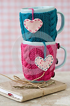Two blue cups in blue and pink sweater with hearts