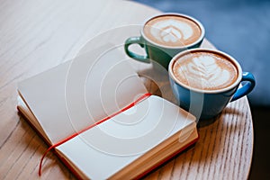 Two cups of cappuccino with notebook photo