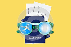 Two blue passports, boarding pass, flight tickets, sunglasses, airplane, sun, blue sky, summer holidays, vacation, travel, tourism