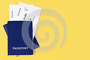 Two blue passports, boarding pass yellow background closeup top view, flight ticket, airplane travel concept,  summer holidays