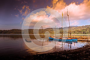Two traditional Balinese fishing boats on the shore of Lake Tamblingan at sunset in Bali, Indonesia, Asia
