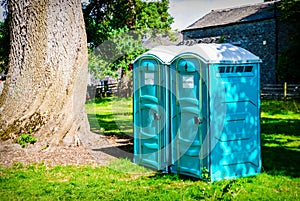 Two blue - white portable toilet cabins at outside event UK