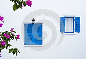Two blue windows on white wall building
