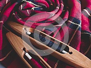 Two boat shuttles and handwoven fabric in red and black colors, close up. Ready weaving project