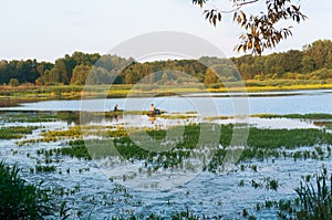 Two boats with fishermen on the river, two fishermen at sunset on the lake