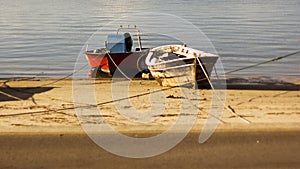 Two boats moored on the beach next to each other