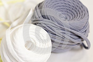 Two bobbins of t-shirt yarn in white and gray colors