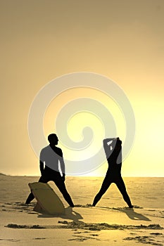 Two bodyboarders at sunset