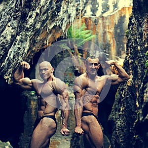 Two bodybuilders posing outdoors - copyspace