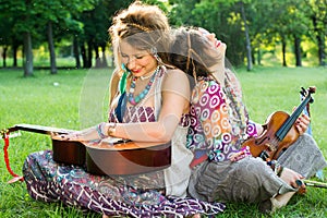 Two Bohemian Musicians sitting on the grass