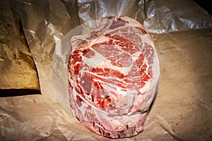Two bone standing rib beef roast raw on butcher paper tied with string