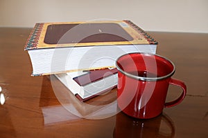 Two books with a cup of coffee on a glassed table photo