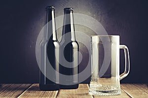 Two bottle and beer mug on a dark background/two bottle and beer mug on a dark background. Selective focus