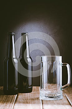 two bottle and beer mug on a dark background/two bottle and beer mug on a dark style. Selective focus