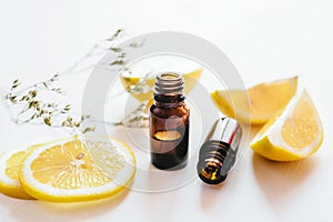 Two bottle of lemon essential oil on white background