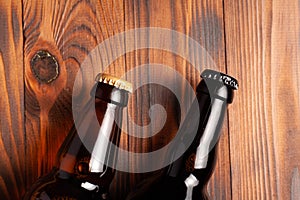 Two bottles of beer lie on an open table with empty space