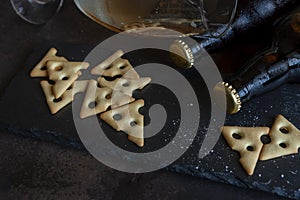 Two Bottles of beer with salted crackers  on dark stone background