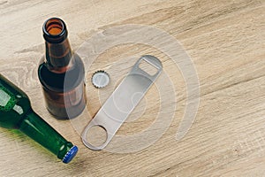 Two bottles of beer and a stainless steel bottle opener