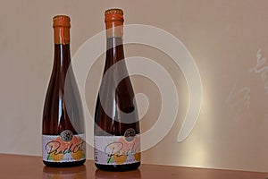 Two bottles of branded beer with a characteristic label. Varvar Peach Beer.