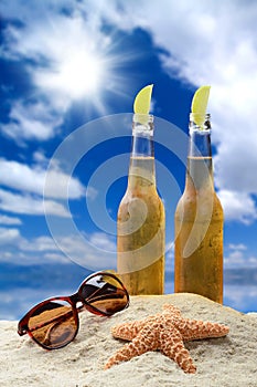 Two bottles of cold beer with lime in a beautiful tropical beach setting