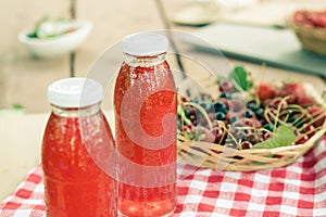 Two bottles of cold stewed fruit from assorted berries.