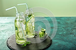 Two bottles of cucumber infused water on table