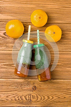 two bottles with a drink of spirulina yogurt and citrus jam on a wooden background