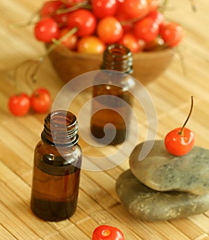 Two bottles of essence oil, stones and fresh cher