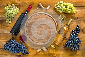 Two bottles and glasses with wine, grapes, corks and a corkscrew