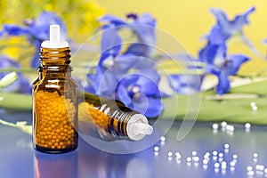 Two bottles with homeopathy globules and flowers