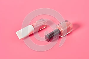 Two bottles of luxury nail polish on pink background