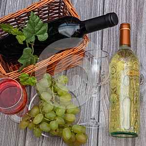 Two bottles of wine with tap and white wine and two glasses on a thin stem