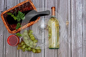 Two bottles of wine with tap and white wine and two glasses on a thin stem