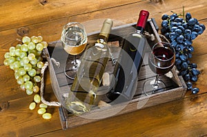 Two bottles with wine on a wooden background.