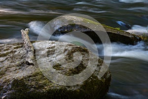 Two boulders in the stream of a fast forest river.
