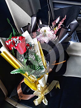 Two bouquet of artificial flowers wrapped in paper