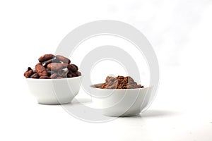 Two bowls with cacao beans and cacao powder isolated on white background