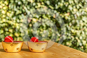 Two bowls with Christmas balls on a wooden table