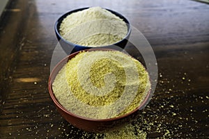 Two bowls of yellow and white Nigerian Garri on Table photo