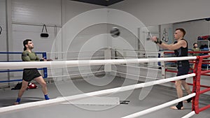 Two boxer man throwing ball while warming training on boxing ring. Fighter man training before boxing with personal