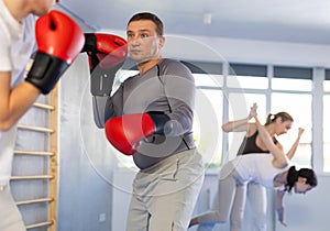 Two boxers in sportswear are engaged in boxing sparring in gym