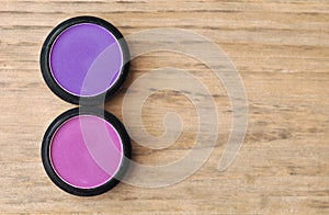 Two Boxes Of Eyeshadows Pink And Violet On Wood Table