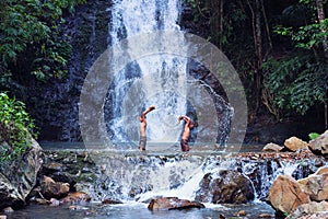 Two boy play and laugh fishing at a waterfall countryside thailand.Fishing boy asian by gaff in creek with beautiful background