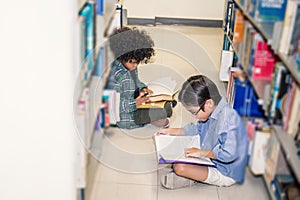 Two boy reading on the library floor photo