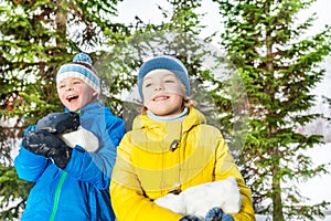 Two boys with big chunk of snow in the park